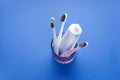 Multi-colored toothbrushes in a glass on a blue background, flat lay Royalty Free Stock Photo