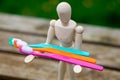 Multi-colored toothbrushes in the hands of a human figure. Cleaning and caring for teeth concept Royalty Free Stock Photo