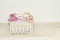 Multi-colored towels rolled into rolls in a white wicker basket on the floor Royalty Free Stock Photo