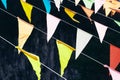 Multi colored triangular flags hanging on the ropes on a dark background Royalty Free Stock Photo