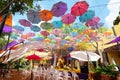 Multi-colored umbrellas background. Colorful umbrellas floating above the street. Royalty Free Stock Photo