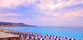 Multi Colored umbrellas on the beach in Nice and turquoise calm water on the Cote d`Azur, France. Sunset at sea