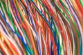 Multi-colored vertical electrical wires. Telecommunication communication wires are intertwined. Thin colored telephone cable.