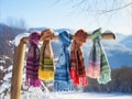 Multi-colored warm scarves hang on a wooden pole