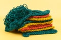 Multi-colored washcloths woven from jute twine and folded in a pile
