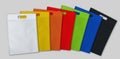 Multi colorful d cut eco friendly non woven bags on white background