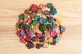 Multi coloured beards hand made from coconut shell flower and rounded pieces, traditional African decoration on a natural wooden b Royalty Free Stock Photo