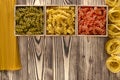 Multi-coloured pasta in the form of spirals lies in square wooden boxes that stand on a table Royalty Free Stock Photo