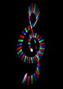 Multi-coloured shone treble clef on black Royalty Free Stock Photo