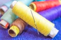 Multi coloured thread rolls with a needle stacked at a workplace for sewing Royalty Free Stock Photo