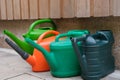 Multi coloured watering cans in a garden Royalty Free Stock Photo