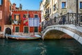 Multi coloured yacht moored on canal with hanging laundry in Venice, Italy