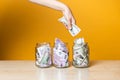 Multi-currency accounts, concept. Dollars and euros in a glass jar on a bright yellow background. Royalty Free Stock Photo