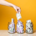 Multi-currency accounts, concept. Dollars and euros in a glass jar on a bright yellow background Royalty Free Stock Photo