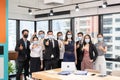 Multi-ethnic business group confident wearing face mask and showing thumbs up in new normal office at business district