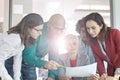 Multi-ethnic business people discussing over document in office Royalty Free Stock Photo