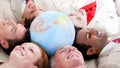 Multi-ethnic business team lying around a globe Royalty Free Stock Photo