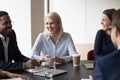 Multiethnic cheerful workmates laughing during group briefing in office boardroom