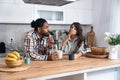 Multi-ethnic couple standing with tea cups in the kitchen and looks at each other with a love. African black man and a caucasian Royalty Free Stock Photo