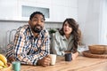 Multi-ethnic couple standing with tea cups in the kitchen and looks at each other with a love. African black man and a caucasian Royalty Free Stock Photo