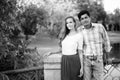 Multi ethnic couple standing together on the bridge of peaceful green park Royalty Free Stock Photo