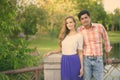 Multi ethnic couple standing together on the bridge of peaceful green park Royalty Free Stock Photo