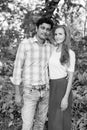 Multi ethnic couple standing together and in love against scenic view of healthy green garden in the park Royalty Free Stock Photo