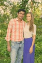 Multi ethnic couple standing together and in love against scenic view of healthy green garden in the park Royalty Free Stock Photo