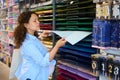 Pregnant woman taking out a color design paper sheet from the shelf in an art store. People. Hobbies and leisures. Art. Royalty Free Stock Photo