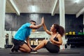 Mixed race friends doing cross fit in the gym. African American male encouraging African American female during sit-ups Royalty Free Stock Photo