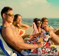 Multi ethnic friends sunbathing on a beach Royalty Free Stock Photo