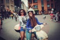 Multi ethnic girls on a scooter in european city