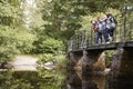 Multi ethnic group of five young adult friends stand looking down from a bridge during a hike Royalty Free Stock Photo