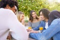 Multi-ethnic group of friends having a drink together in an outdoor bar. Royalty Free Stock Photo