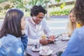 Multi-ethnic group of friends having a drink together in an outdoor bar. Royalty Free Stock Photo