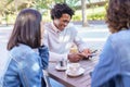 Multi-ethnic group of friends having a drink together in an outdoor bar. Royalty Free Stock Photo