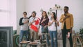 Multi ethnic group of friends listening and singing national Canadian anthem before watching sports championship on TV Royalty Free Stock Photo
