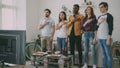 Multi ethnic group of friends sport fans singing national anthem before watching sports championship on TV together at Royalty Free Stock Photo