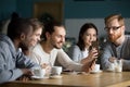 Multi-ethnic group of friends talking and using smartphones at m Royalty Free Stock Photo