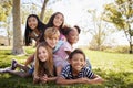 Multi-ethnic group of kids lying on each other in a park