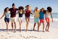 Multi-ethnic group of male and female standing on the beach Royalty Free Stock Photo