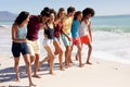 Multi-ethnic group of male and female standing on the beach Royalty Free Stock Photo