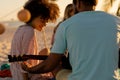 Mixed race friends group playing guitar on beach Royalty Free Stock Photo