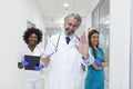 A multi-ethnic group of three doctors and nurses standing in a hospital corridor, wearing scrubs and coats. The team of healthcare Royalty Free Stock Photo