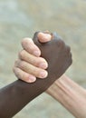 Multi-Ethnic hands in handshake close-up on abstract background Royalty Free Stock Photo