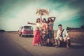 Multi-ethnic hippie hitchhikers with guitar and luggage on a road Royalty Free Stock Photo