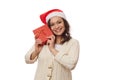 Pretty woman in Santa hat, with a Christmas gift, smiling a toothy smile looking at camera, isolated on white background Royalty Free Stock Photo