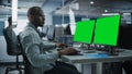 Multi-Ethnic Office: Black IT Programmer Working on Computer with Green Screen Chroma Key Display Royalty Free Stock Photo