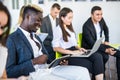 Multi-ethnic office people group using gadgets at team meeting, serious executives working on mobile phones during corporate Royalty Free Stock Photo