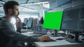 Multi-Ethnic Office: White IT Programmer Working on Computer with Green Screen Chroma Key Display Royalty Free Stock Photo
